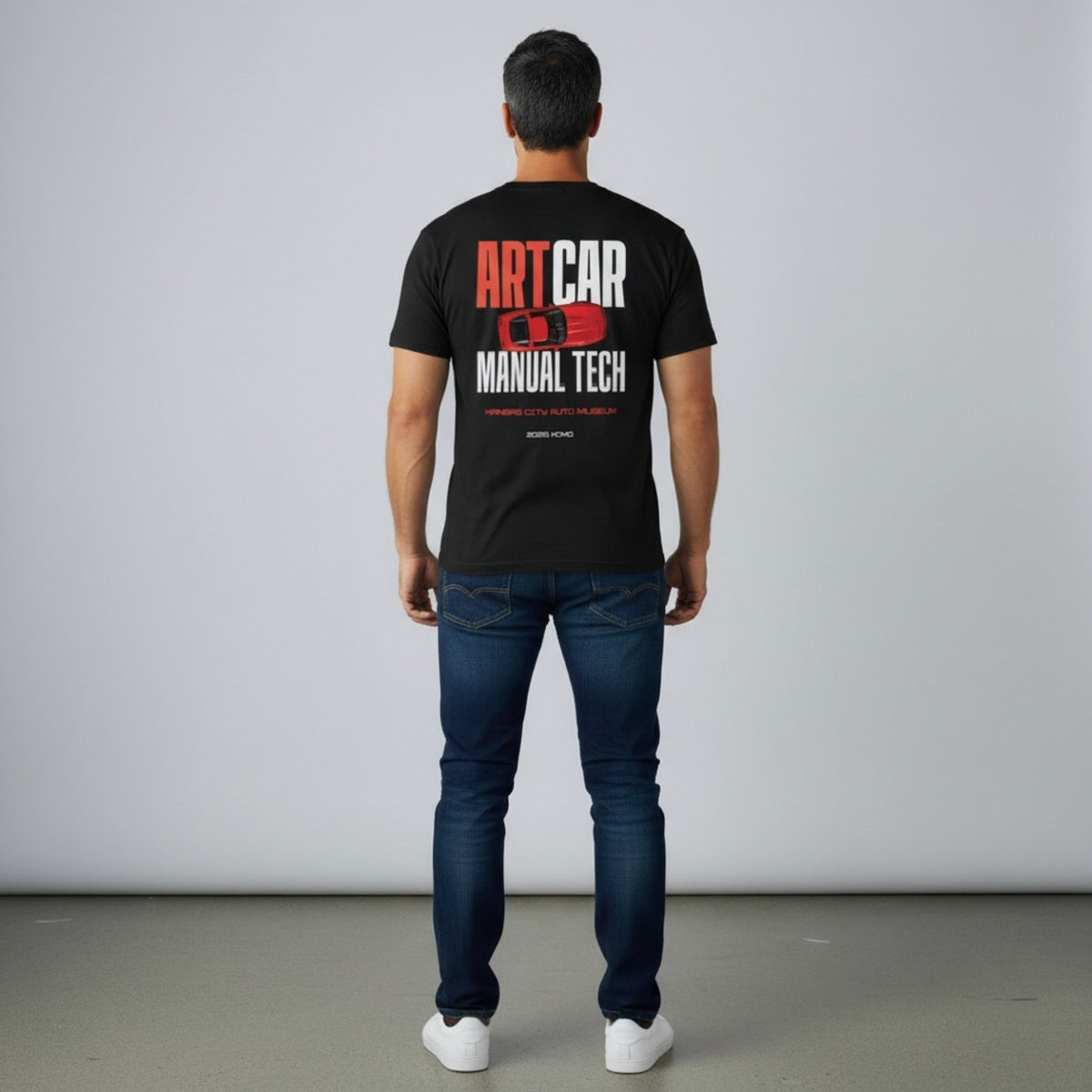 A second model wearing the black KCAM Art Car tee seen from behind, showing the full ARTCAR MANUAL TECH back print