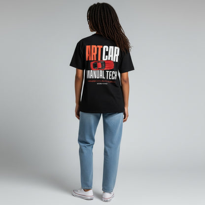 A model wearing the black KCAM Art Car tee seen from behind, showing the full ARTCAR MANUAL TECH back print with a red art car above Kansas City Auto Museum, 2026 KCMO