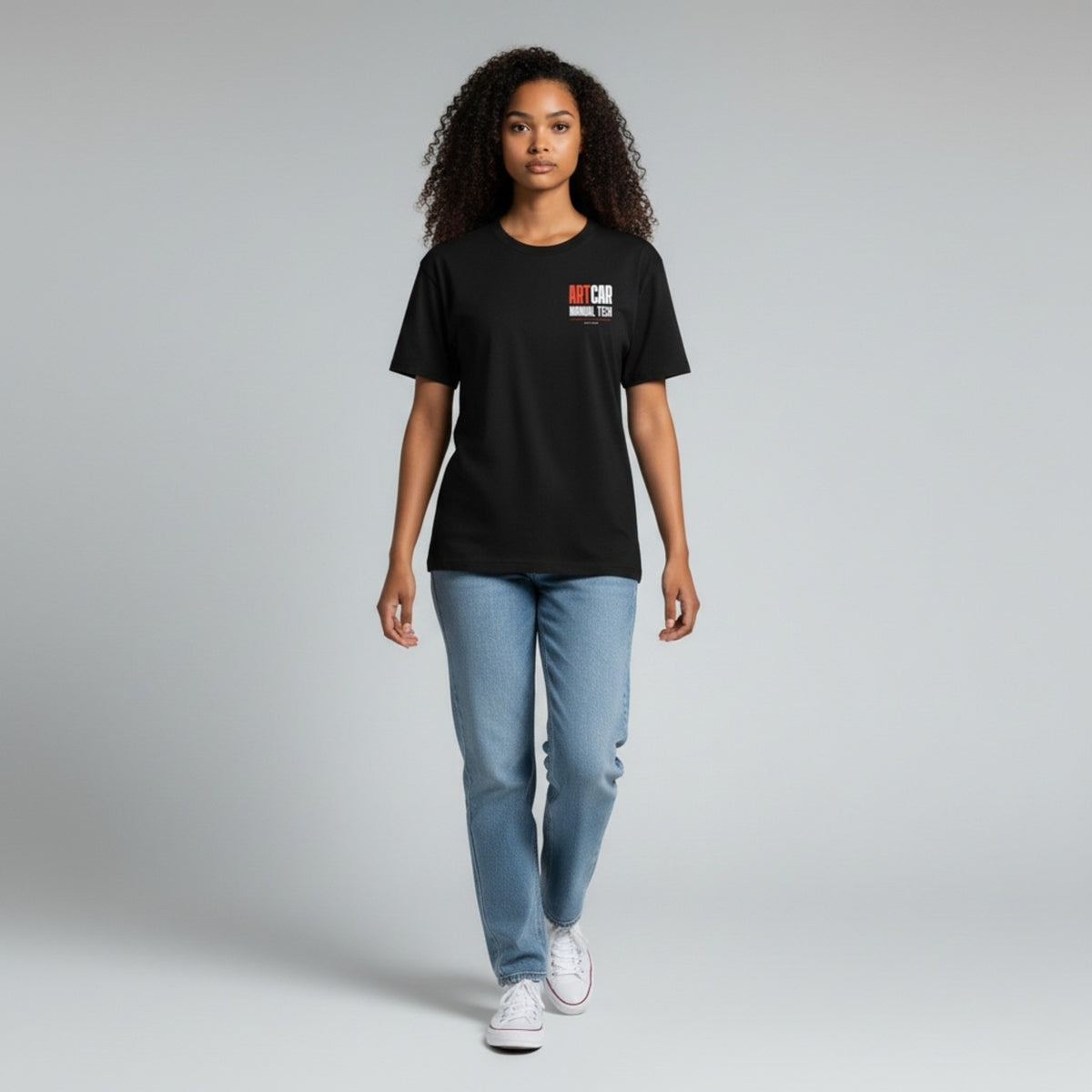 A model wearing the black KCAM Art Car tee, front view, standing, with the ARTCAR MANUAL TECH print on the left chest