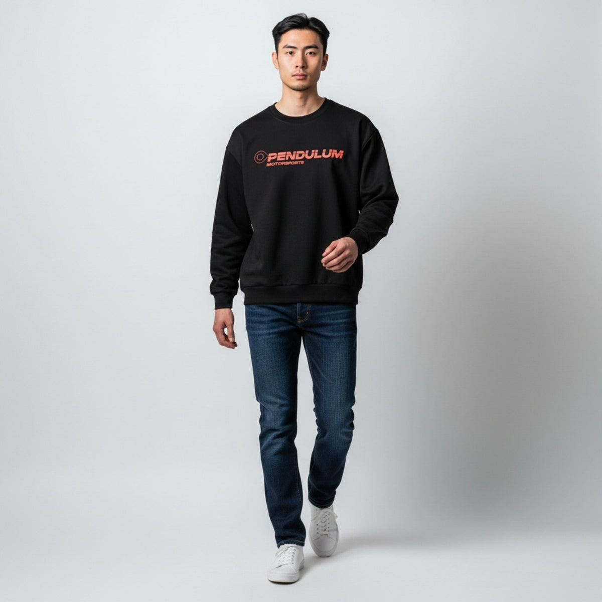 A model wearing the black 1991 Honda CRX Turbo crewneck with the coral Pendulum Motorsports wordmark on the chest, full length